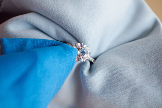 wiping a diamond ring with a microfiber towel after cleaning